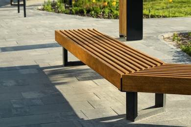 Wooden bench in city park on sunny morning