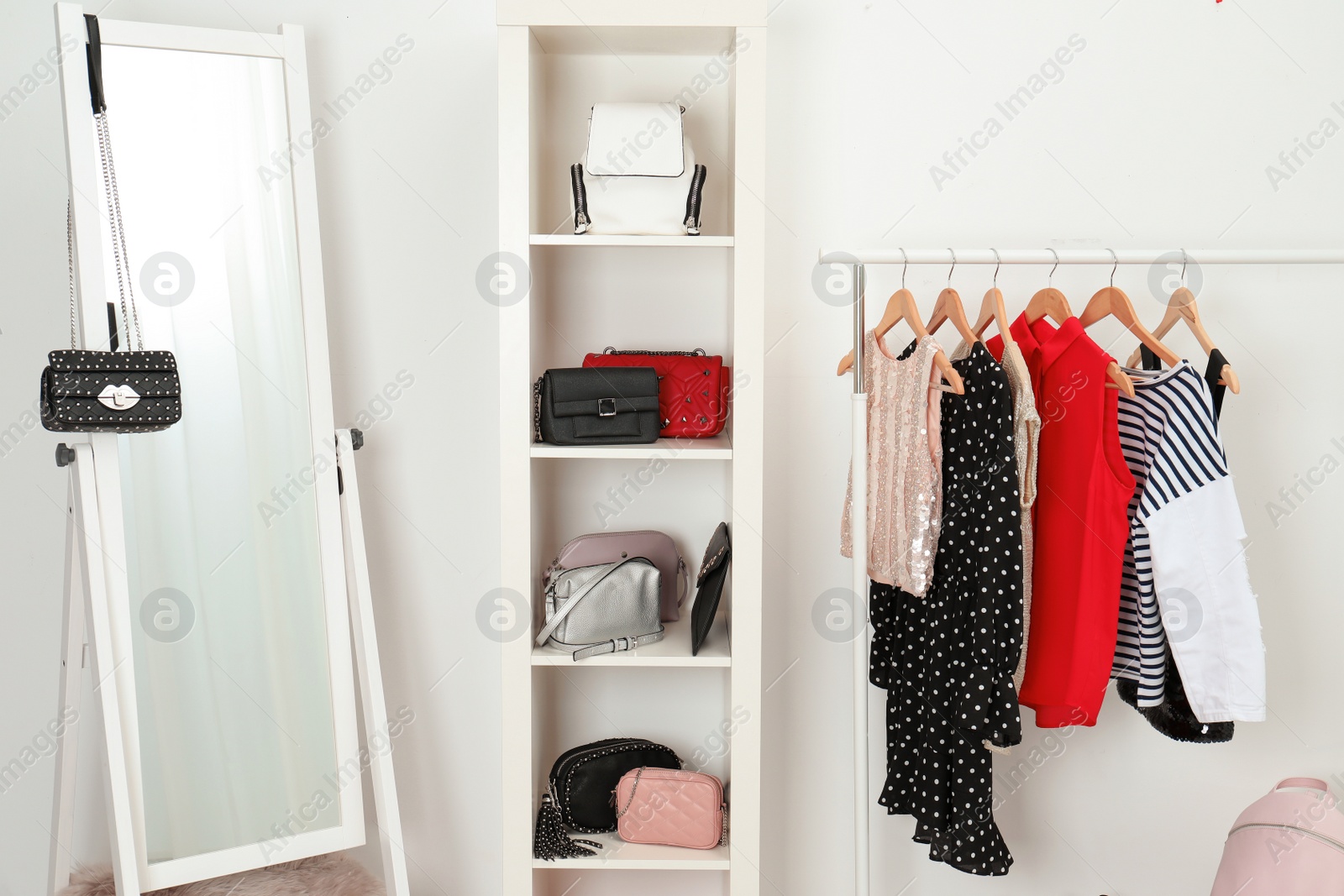 Photo of Wardrobe with stylish bags and clothes indoors. Idea for interior design