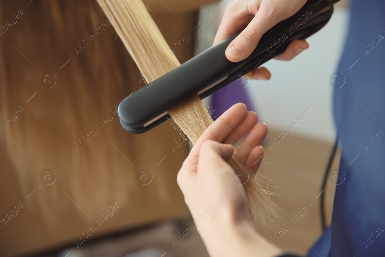 Photo of Professional hairdresser working with client in salon