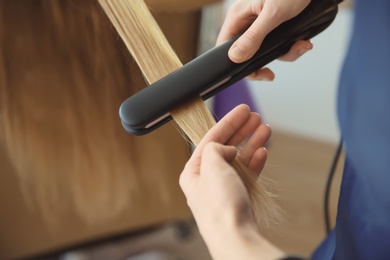 Photo of Professional hairdresser working with client in salon