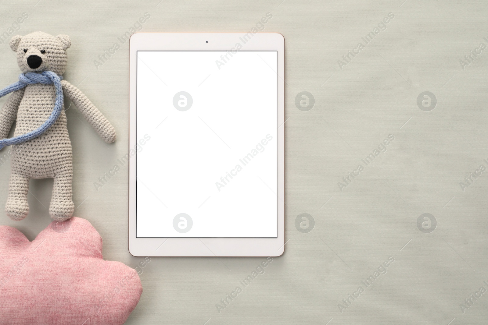 Photo of Modern tablet, toy cloud and bear on light background, flat lay. Space for text