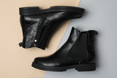 Photo of Stylish black female boots on color background, flat lay