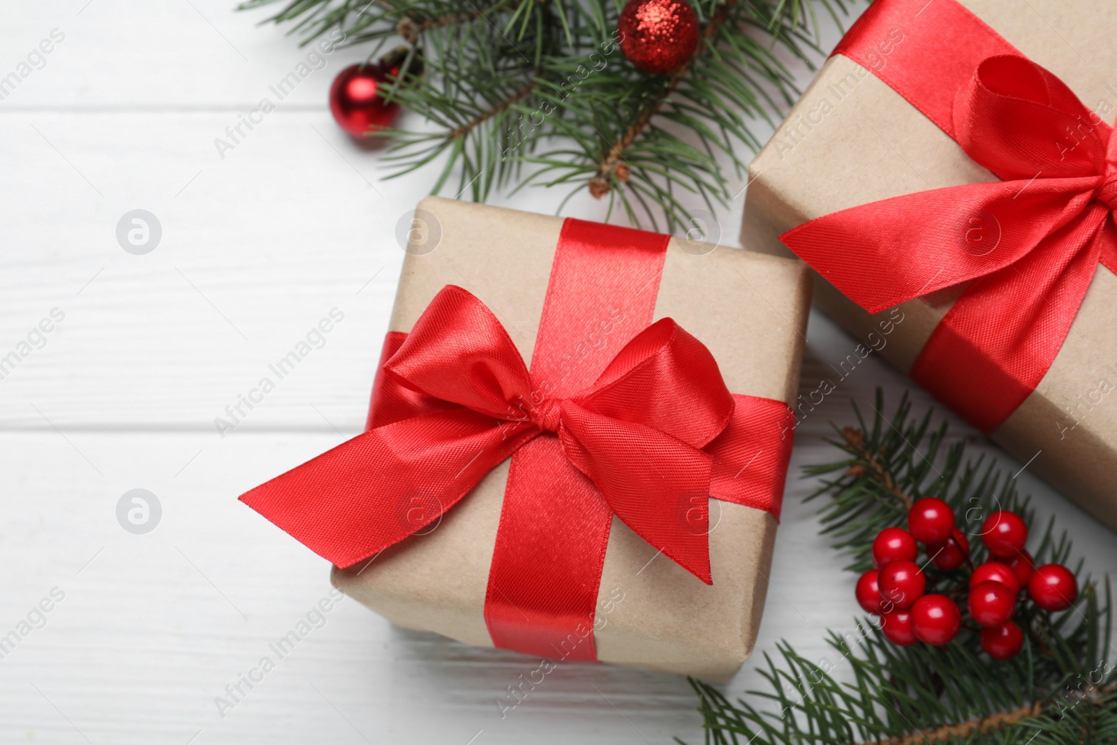 Photo of Flat lay composition with gift boxes and Christmas decorations on white wooden table