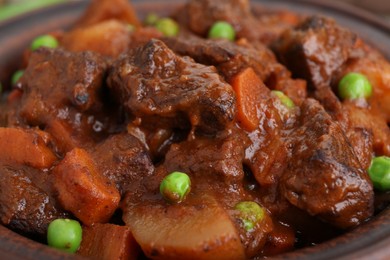 Photo of Delicious beef stew with carrots, peas and potatoes, closeup