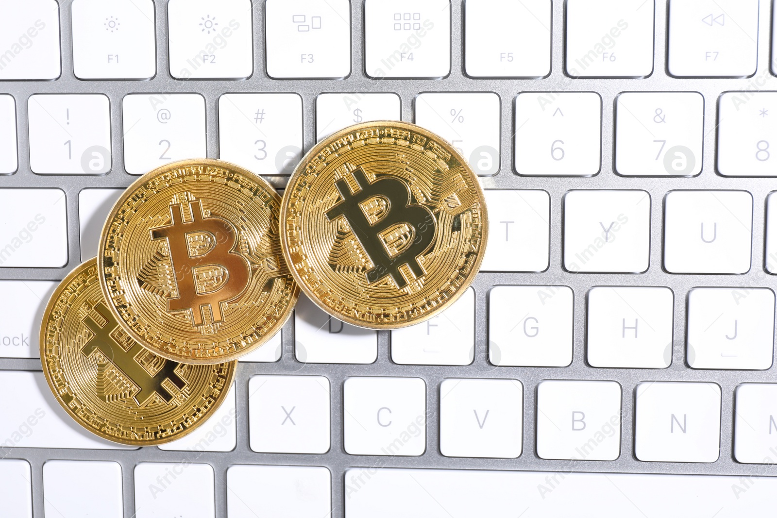 Photo of Golden bitcoins on computer keyboard, flat lay. Space for text
