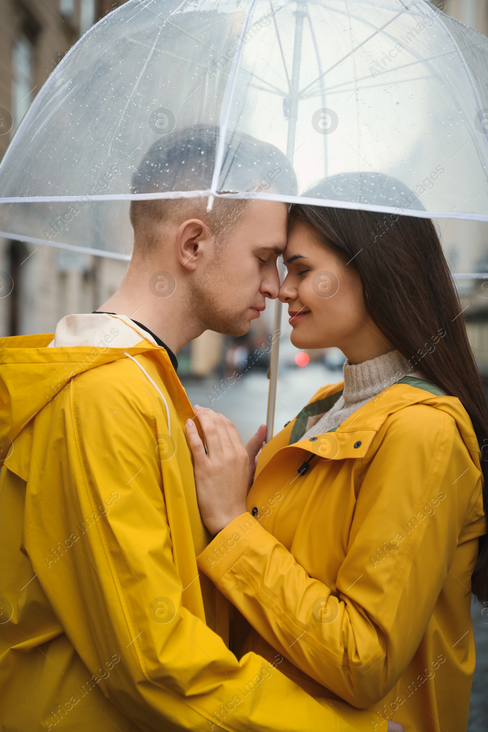 Photo of Lovely young couple with umbrella on city street