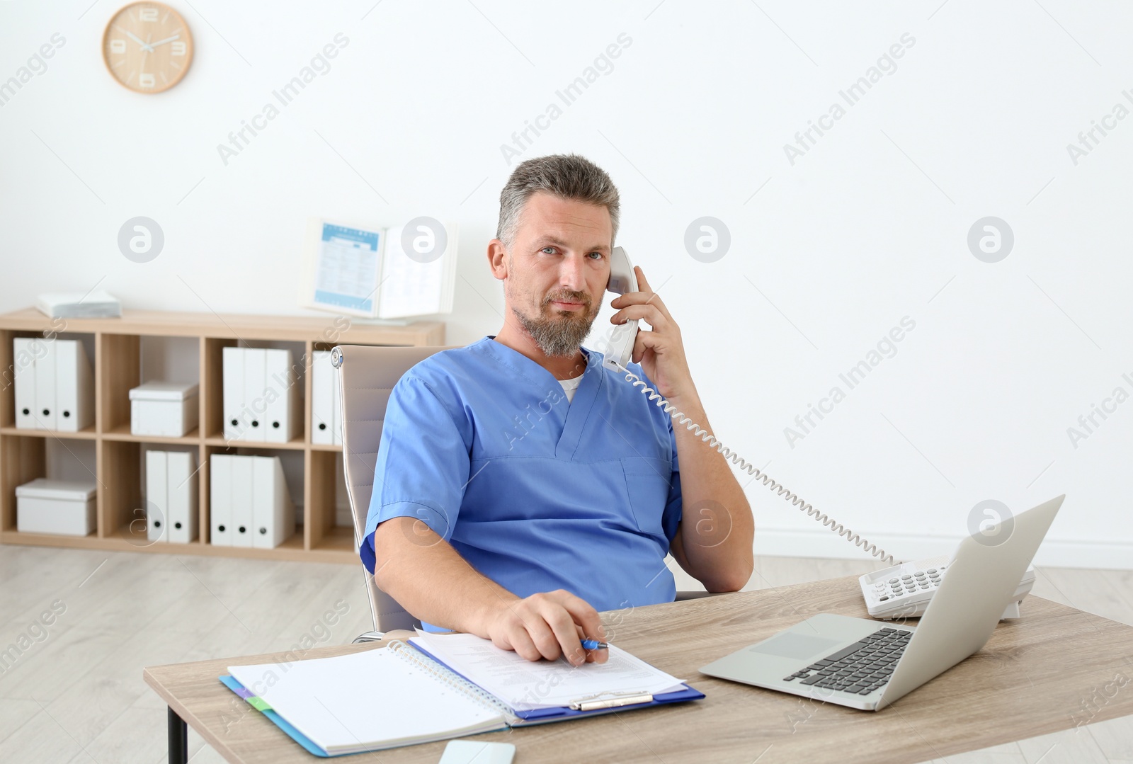 Photo of Male medical assistant at workplace in clinic. Health care service