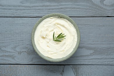 Photo of Delicious tofu cream cheese with rosemary in bowl on grey wooden table, top view