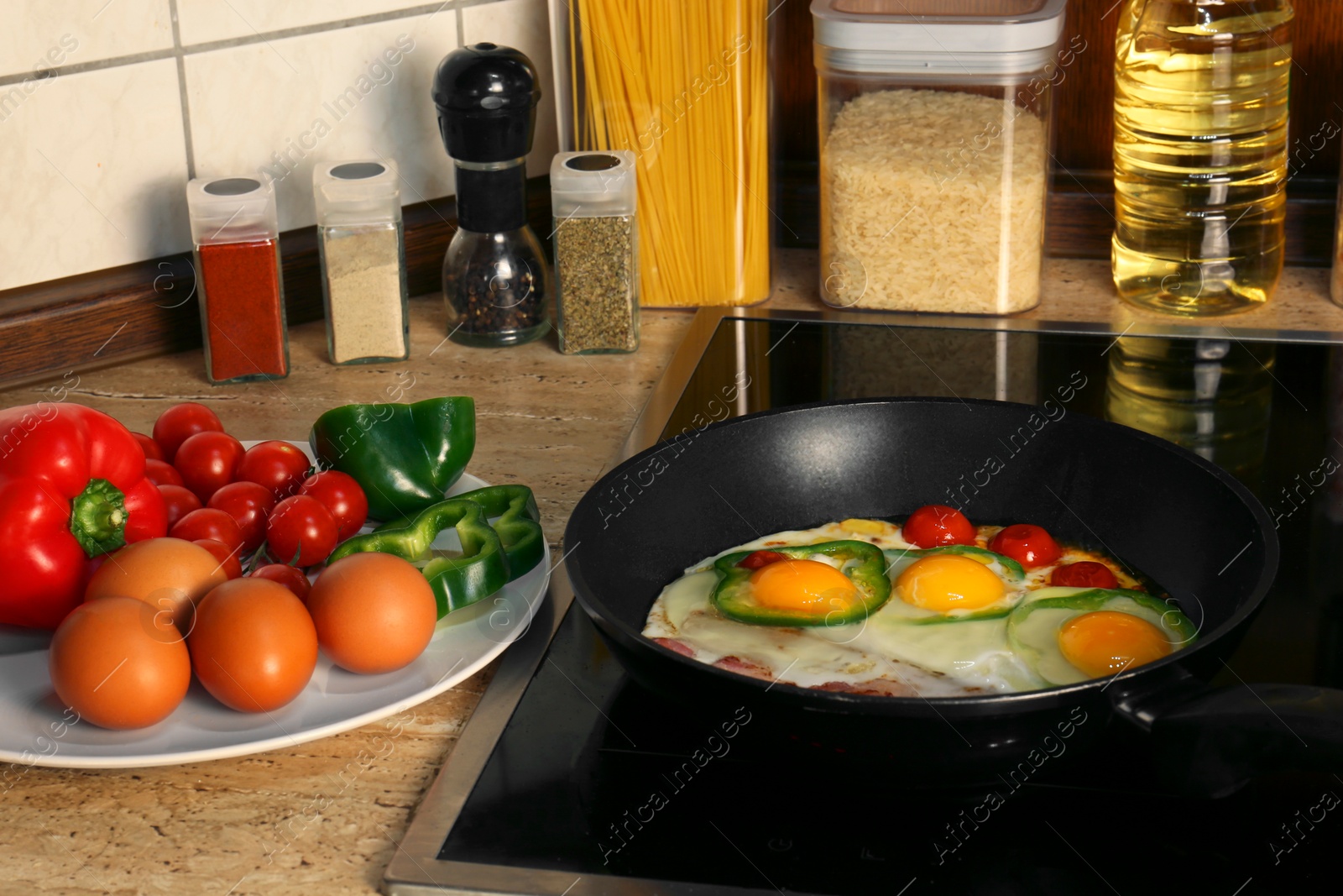 Photo of Cooking eggs with bacon, tomatoes and pepper in frying pan