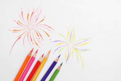 Photo of Abstract drawing and colorful pencils on white background, top view