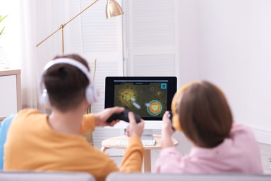 Photo of Young couple playing video games at home