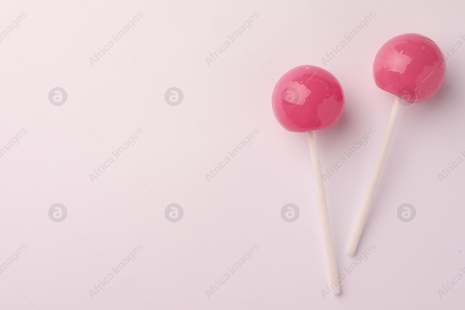 Photo of Tasty lollipops on white background, flat lay. Space for text