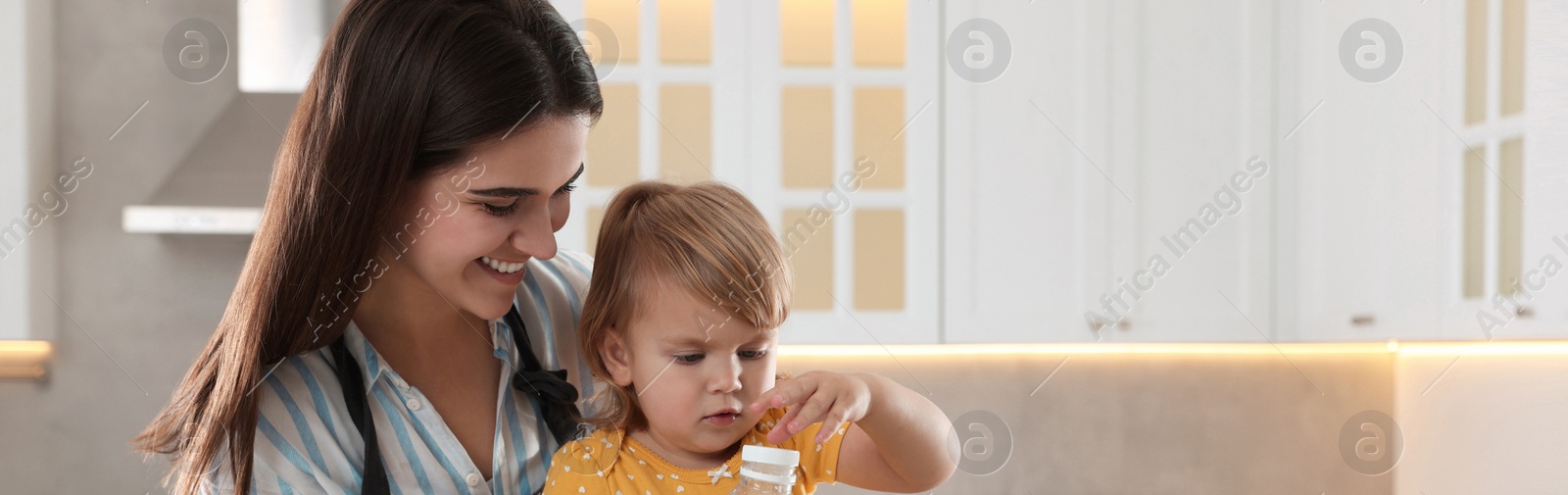 Image of Mother and her little daughter cooking together in kitchen, space for text. Banner design