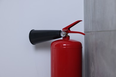 Photo of One red fire extinguisher in corner indoors