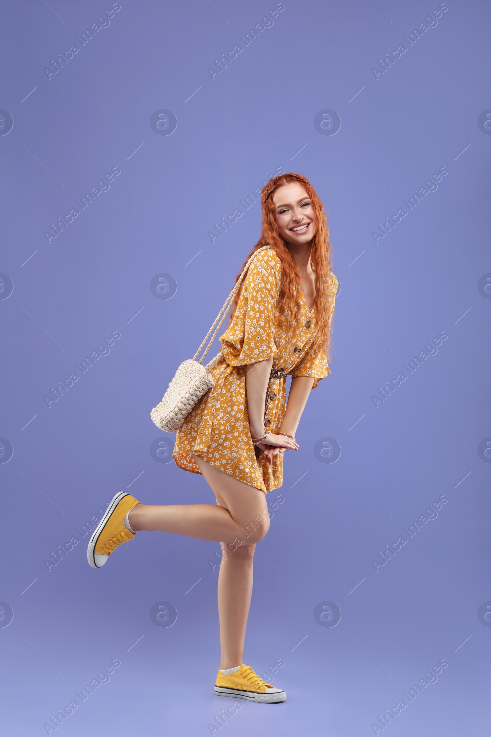 Photo of Stylish young hippie woman on violet background