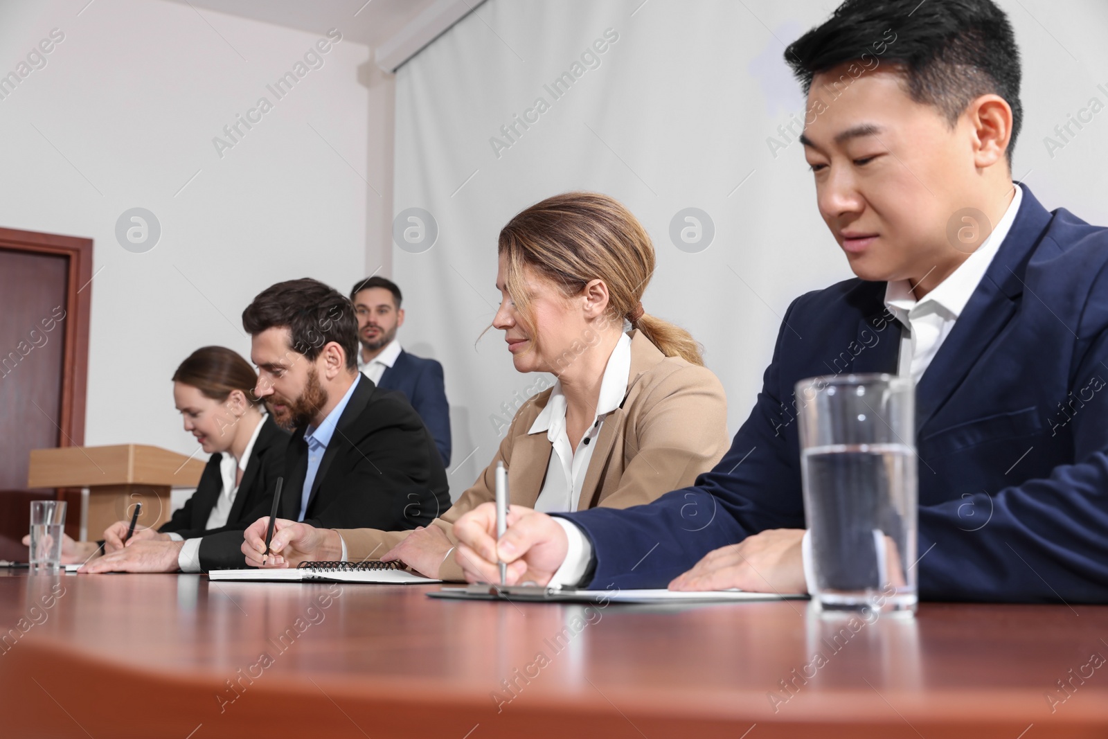 Photo of Business conference. People working at wooden table in meeting room