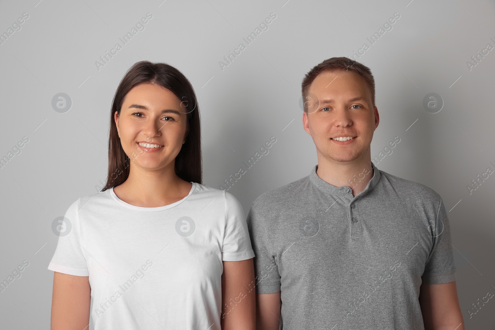 Photo of Portrait of happy young woman and man on light background