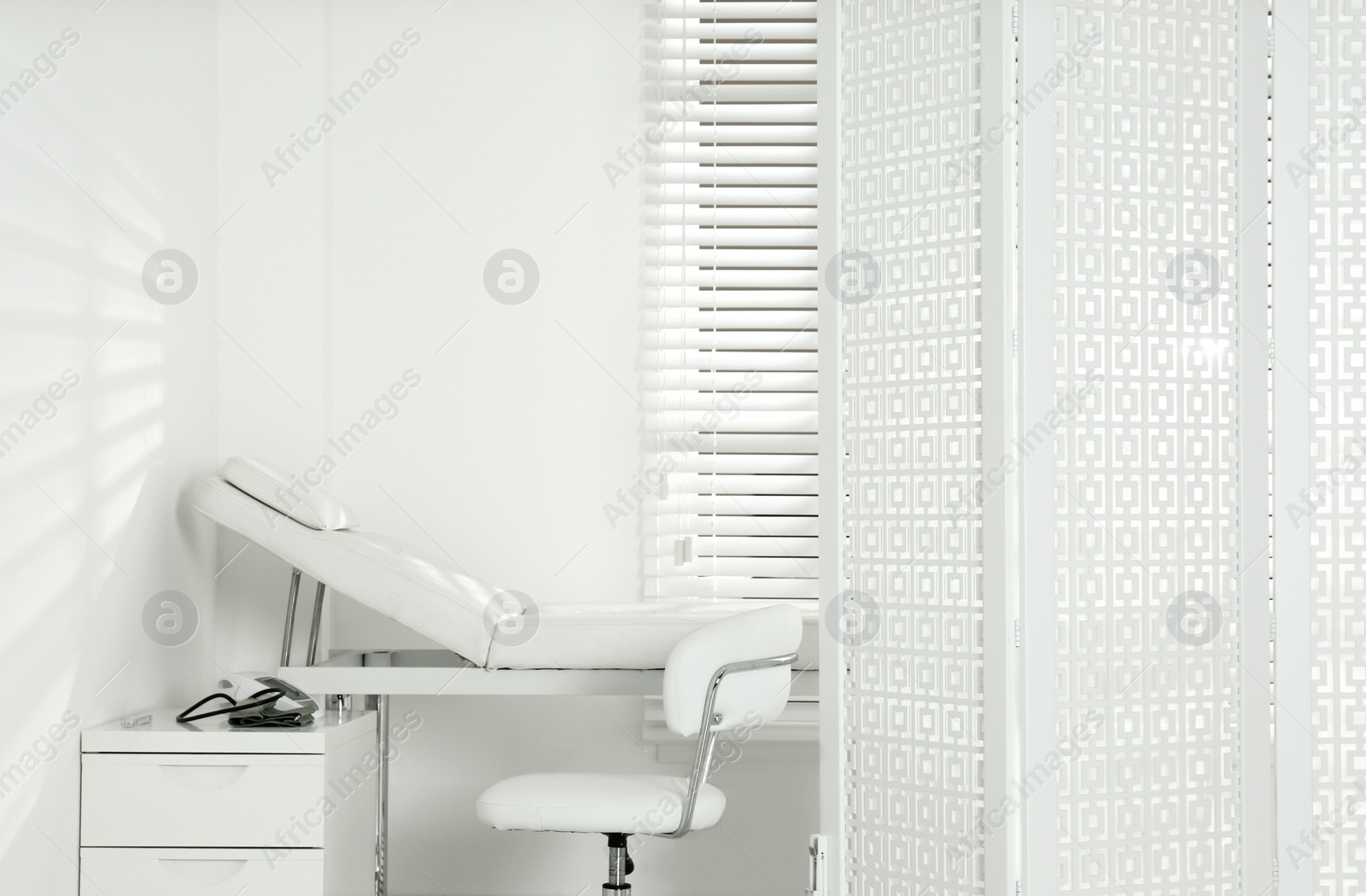 Photo of Examination room with modern couch and folding screen in clinic