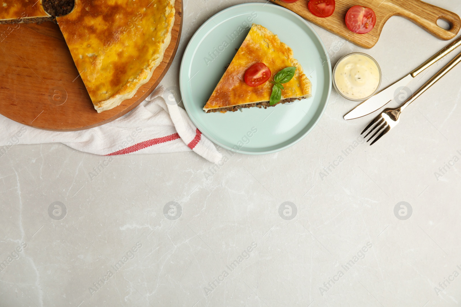 Photo of Delicious pie with minced meat, tomato and sauce served on light marble table, flat lay. Space for text