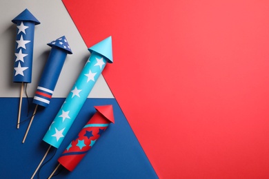 Firework rockets on color background, flat lay with space for text. Festive decor