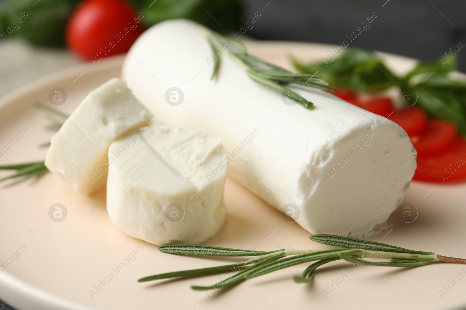 Photo of Delicious goat cheese with rosemary on plate, closeup