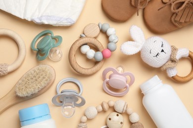 Photo of Flat lay composition with pacifiers and other baby stuff on beige background