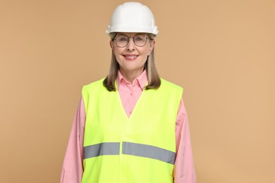 Portrait of architect in hard hat on beige background