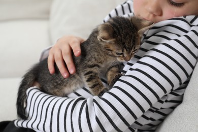 Photo of Little girl with cute fluffy kitten, closeup