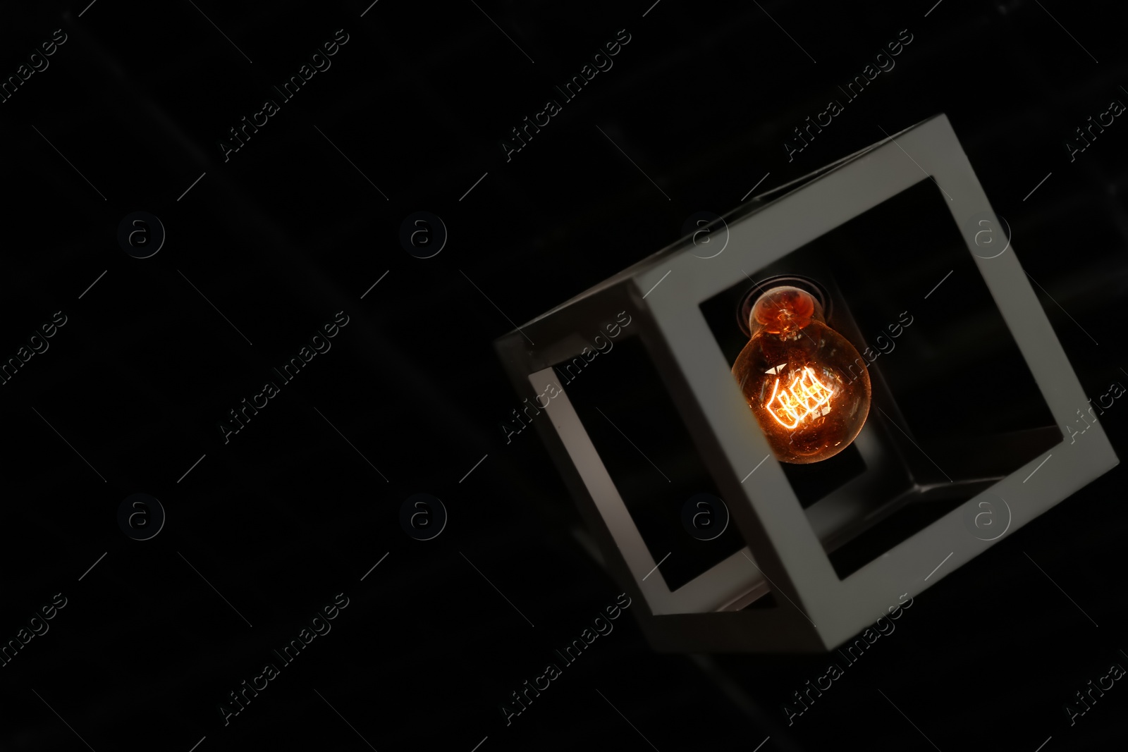 Photo of Creative pendant lamp in dark room. Space for text