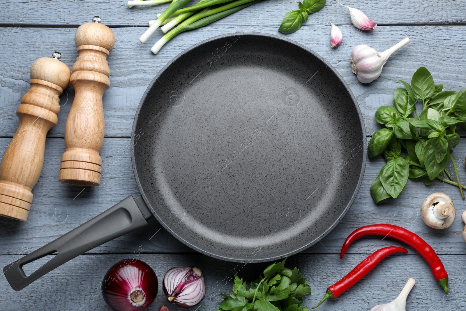 Photo of Flat lay composition with frying pan and fresh products on grey wooden table