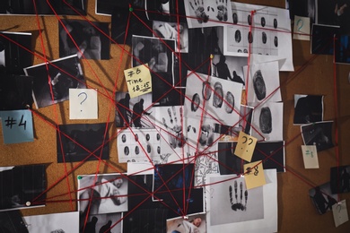 Photo of Detective board with fingerprints, crime scene photos and red threads