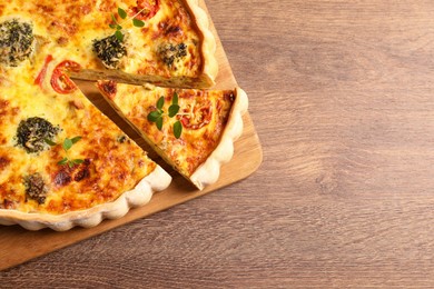 Photo of Delicious homemade vegetable quiche on wooden table, top view. Space for text