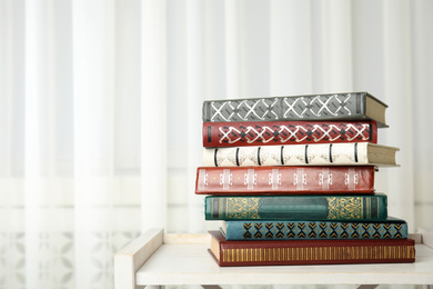 Collection of different books on table indoors. Space for text