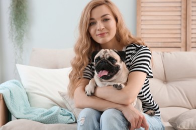 Woman with cute pug dog at home. Animal adoption