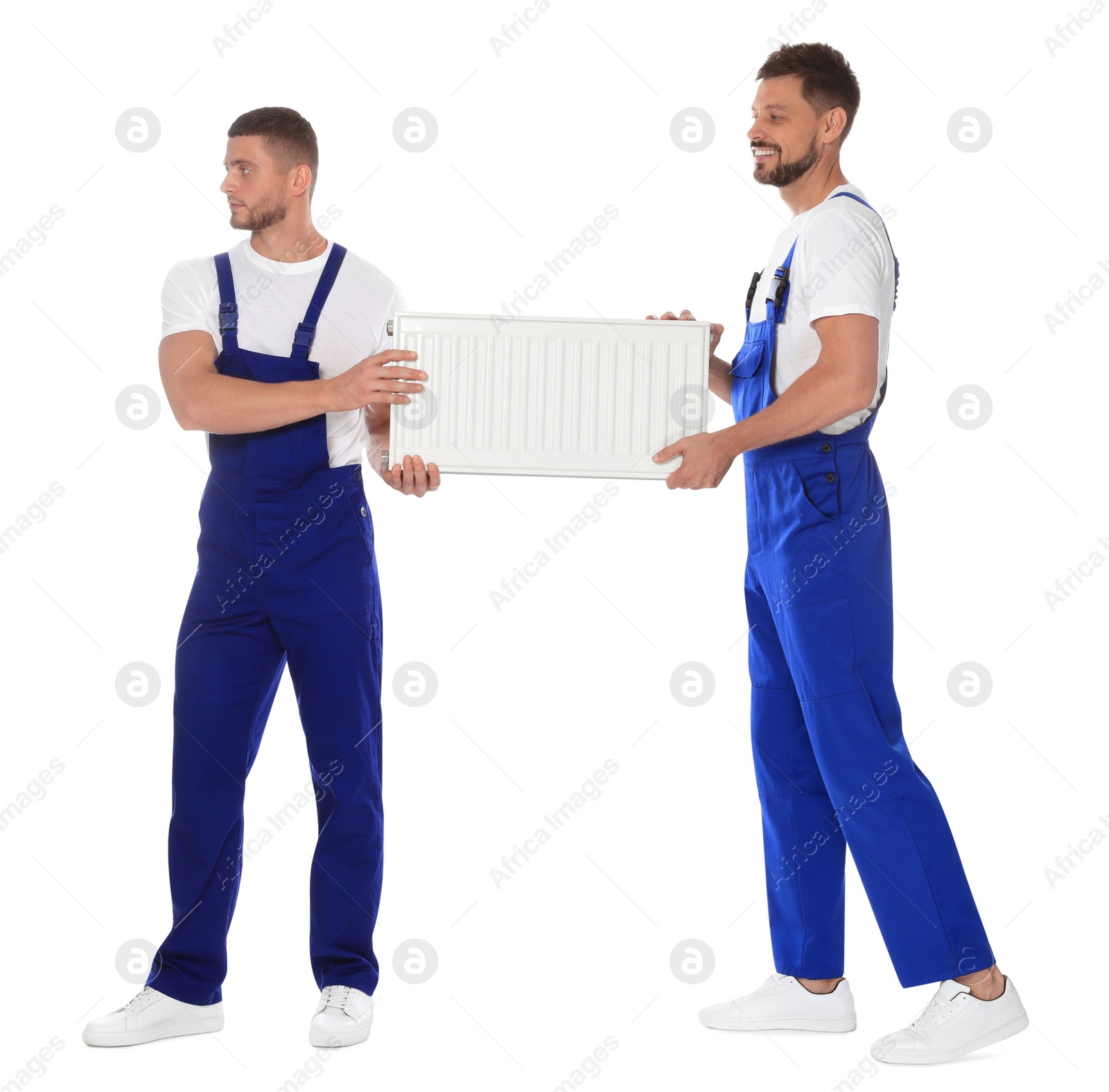 Photo of Professional plumbers with new heating radiator on white background