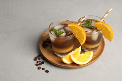 Photo of Tasty refreshing drink with coffee and orange juice on grey table