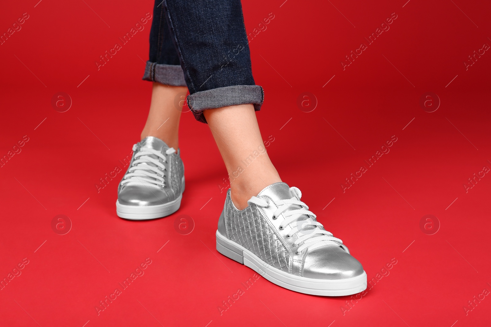 Photo of Woman in stylish sport shoes on color background