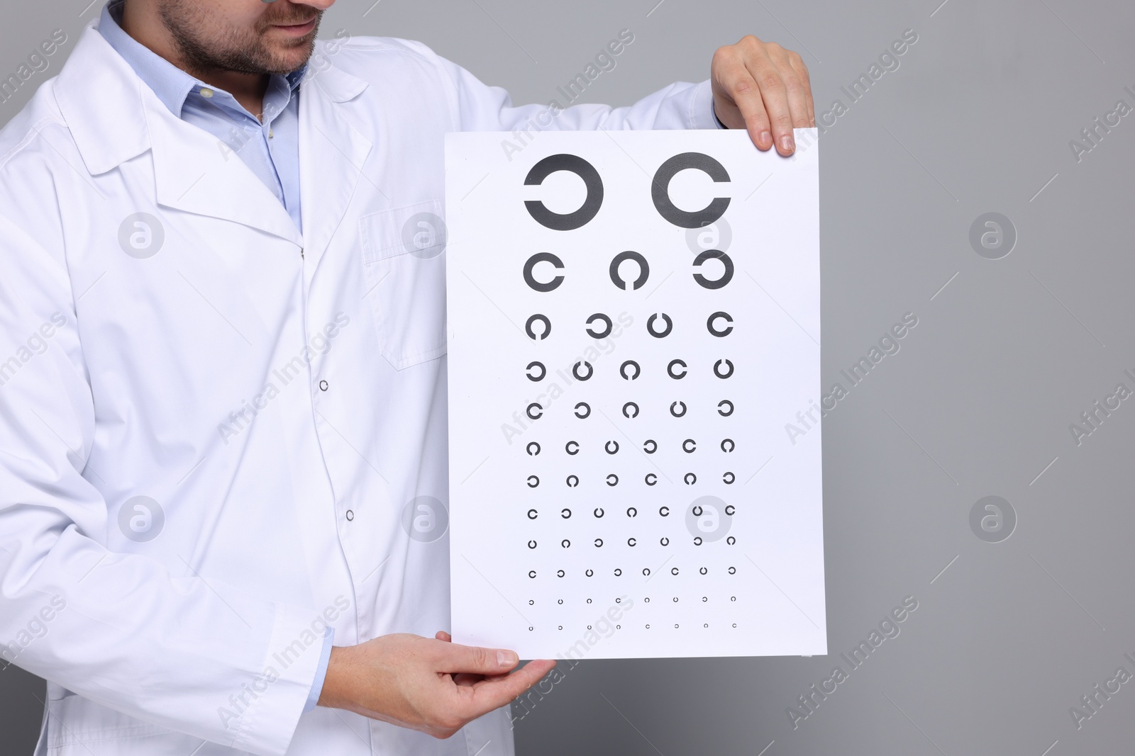 Photo of Ophthalmologist with vision test chart on gray background, closeup