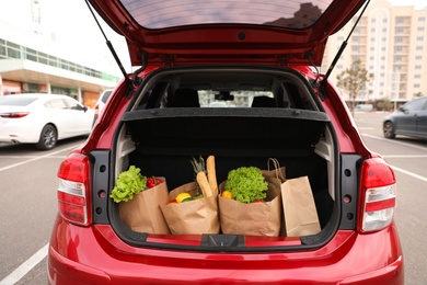 Photo of Bags full of groceries in car trunk outdoors