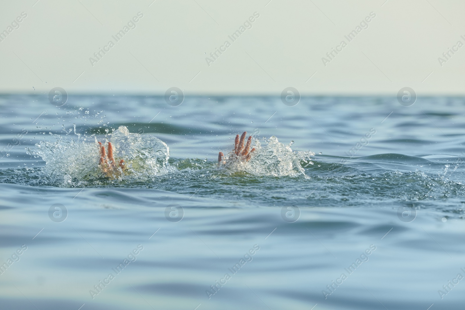 Photo of Drowning woman reaching for help in sea