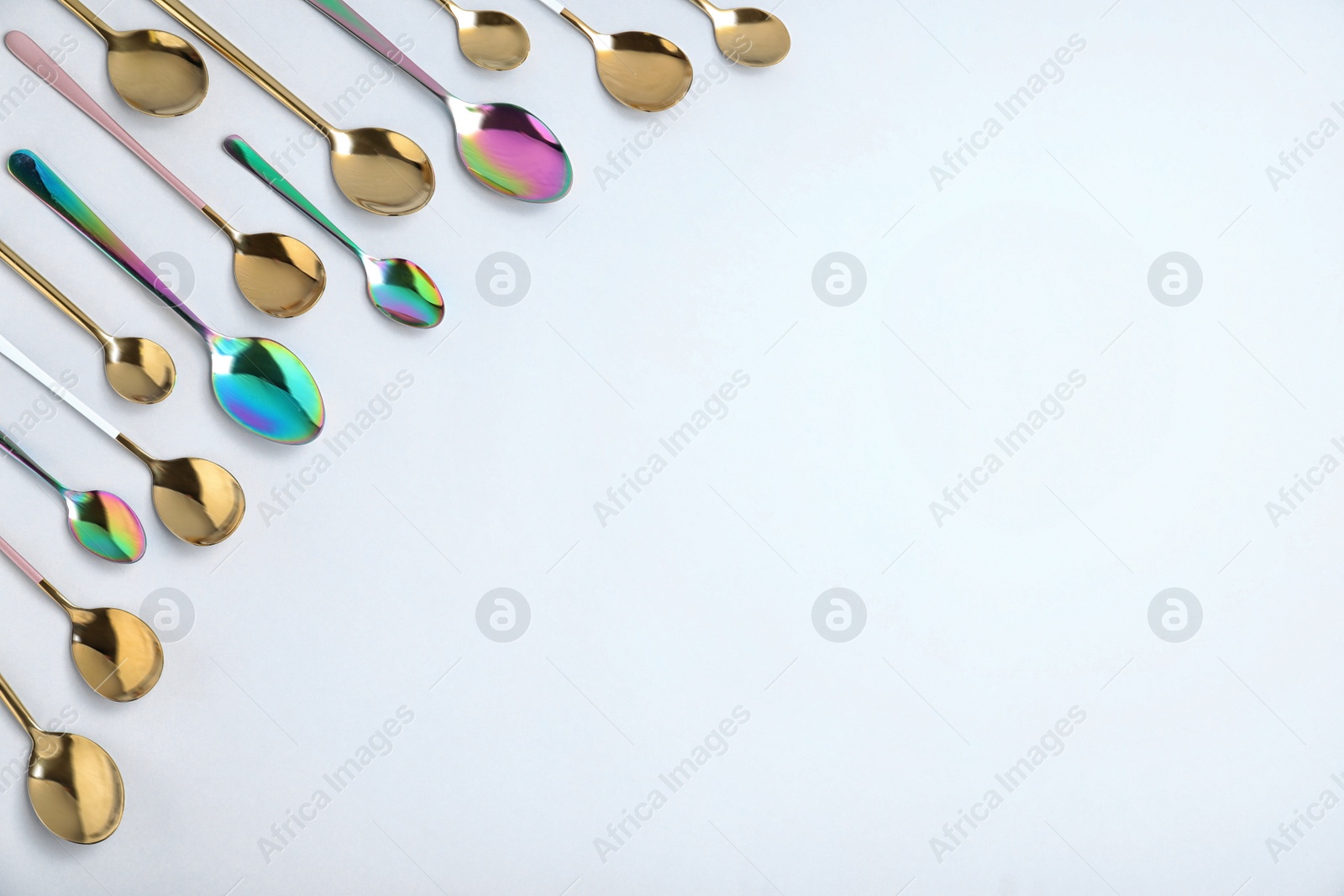 Photo of Set of new luxury spoons on white background, top view. Space for text