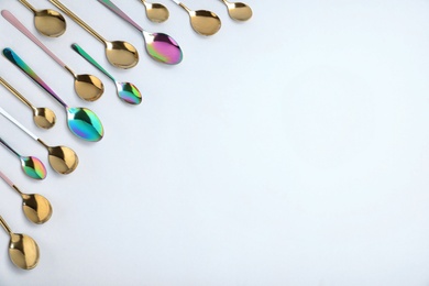 Set of new luxury spoons on white background, top view. Space for text