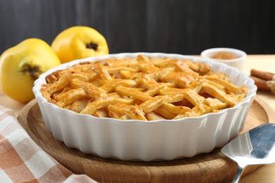 Photo of Tasty homemade quince pie and cake server on table, closeup