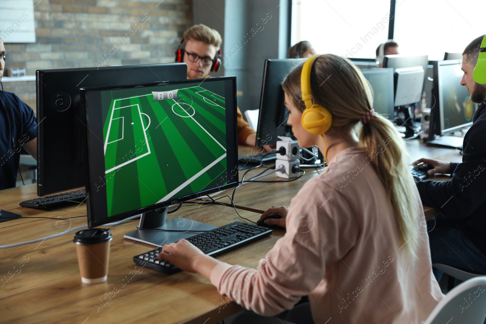 Photo of Woman playing video game in internet cafe