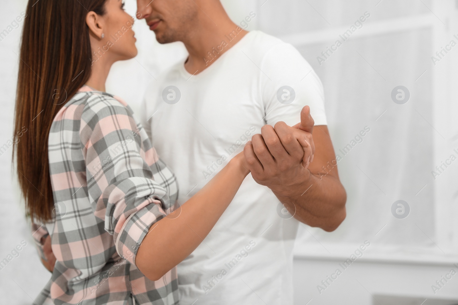 Photo of Happy young couple dancing at home, focus on hands