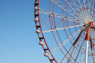 Photo of Beautiful large Ferris wheel against blue sky, space for text