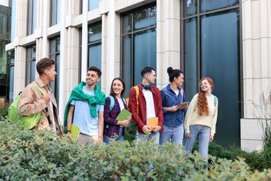 Photo of Group of happy students walking together outdoors