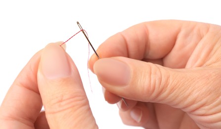 Photo of Woman threading sewing needle on white background, closeup