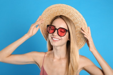 Photo of Beautiful woman in stylish sunglasses on light blue background