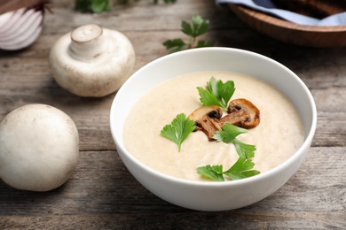 Bowl of fresh homemade mushroom soup on wooden table